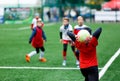 Football teams - boys in red, blue, white uniform play soccer on the green field. boys dribbling. dribbling skills.