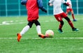 Football teams - boys in red, blue, white uniform play soccer on the green field. boys dribbling. dribbling skills. Team game Royalty Free Stock Photo