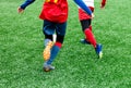 Football teams - boys in red, blue, white uniform play soccer on the green field. boys dribbling. Team game, training, active life Royalty Free Stock Photo