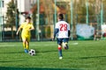 Football teams boys in yellow white sportswear play soccer on the green field. Dribbling skills. Team game, Training