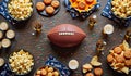 Football-themed party spread with snacks and drinks arranged around a football on a wooden table Royalty Free Stock Photo