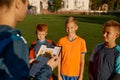 Football trainer talking to team of little players on field during break Royalty Free Stock Photo