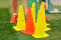 Football Training Cones. Coach Preparing Practice Soccer Field With Red and Yellow Training Cones