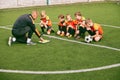 Football training. Soccer coach explaining game rules and strategy using tablet, map. Sports junior team sitting on Royalty Free Stock Photo