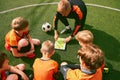 Football training. Soccer coach explaining game rules and strategy using tablet, map. Sports junior team sitting on Royalty Free Stock Photo