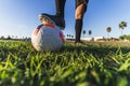 Footballer's foot on the ball on the lawn, the concept of a healthy sporty lifestyle