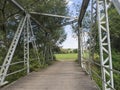 Footbridge across Jizera river made of wood and metal steel girder with view on trees and rural summer landscape