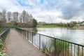 A footbridge on a lake surrounded by lush greenery