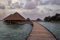 Footbridge leading to wooden bungalows over the sea Royalty Free Stock Photo