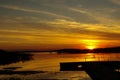 Footbridge at sunset by the lake, reflection of the sun Royalty Free Stock Photo