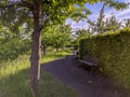 Foothpath and benches along a hedge and trees