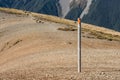 Footpath across scree slope with poles marking way