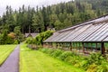 A footpath along a greenhouse with exotic plants and flowers in Benmore Botanic Garden, Scotland