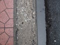 Footpath border with tile, cement, drain water, and paved road