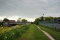 Footpath on the edge of town with rolling grey clouds. June 2021