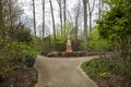 a footpath in the garden with colorful skeleton sculptures of La Catrina of DÃÂ­a de los Muertos, colorful flowers, green trees