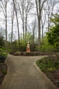 a footpath in the garden with colorful skeleton sculptures of La Catrina of DÃÂ­a de los Muertos, colorful flowers, green trees