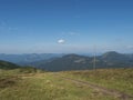 Footpath of hiking trail from Chopok ridge with mountain meadow, scrub pine and view of blue green hills ridge Royalty Free Stock Photo