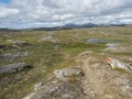 Footpath in northern artic landscape, tundra in Swedish Lapland with green hills, blue lakes and mountains at