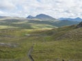 Footpath in northern artic landscape, tundra in Swedish Lapland with green hills and mountains at Padjelantaleden hiking