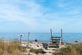 Footpath with a stile across a fence by the sea Royalty Free Stock Photo