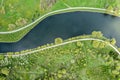 Footpaths curving through green grass on riverbank. summer park. aerial view