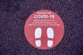 Footprint floor sticker, foot steps in circle, keep distance waiting in line, stand here sign, coronavirus or Covid-19