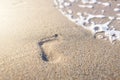 Footprint with golden sand. Beach, wave and footstep on sunny day Royalty Free Stock Photo