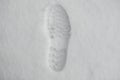 Footprint from a shoe in the snow. Single clearly defined footprint of a shoe or boot in snow. Top view. Copy, empty space for