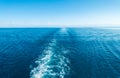 Footprint on the water from the ship. White wave on blue water. Blue sea water. Water and sky Royalty Free Stock Photo