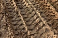 Footprint of wheel tread on the ground road. The trail from the tread of trucks wheels. Car tire tread imprint on sand, background Royalty Free Stock Photo