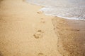 Footprints of bare feet on wet sand. Summer vacation on the beach. Walk along the sea shore Royalty Free Stock Photo