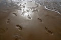 Footprints in the beach sand, licked by the waves of the sea. Royalty Free Stock Photo