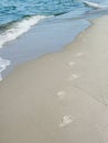 Footprints in sand vanishing in waves Royalty Free Stock Photo