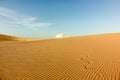 Footprints on beautiful sand dunes with blue sky and white clouds Royalty Free Stock Photo