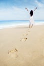 Footprints and carefree woman