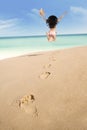 Footprints and excited woman running at beach 1 Royalty Free Stock Photo