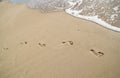 Beach, wave and footprints, work life balance concept Royalty Free Stock Photo