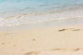 Footprints in the sand. Beautiful sandy tropical beach with sea waves. Footsteps on the shore Royalty Free Stock Photo