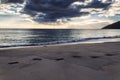 Footprints on sand and evening sea view at Makua beach, Oahu