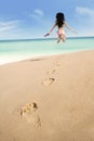 Footprints on sand and jumping woman Royalty Free Stock Photo