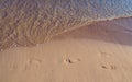 Footprints in the sand with small wave approaching Royalty Free Stock Photo