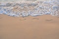 Footprints in the sand at sunset. Beautiful sandy tropical beach with sea waves. Footsteps on the shore.Sea, waves and Royalty Free Stock Photo