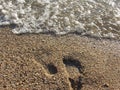 footprints in the sand, washed away by water, on the shore of the lake on a summer day Royalty Free Stock Photo