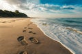 Footprints on sandy beach being washed away, transient imprints