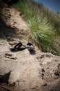 footprints and shoes of a loving young couple cuddling on the sand beach in the summer Royalty Free Stock Photo