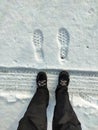 Footprints of shoes on a snow-covered road. A walk in the winter in the snow.