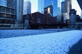 Footprints on snow covered riverwalk across a frozen and ice chunk filled Chicago River