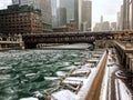 Footprints in snow covered riverwalk alongside Chicago River during heavy snowfall on December afternoon.