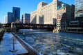 Footprints on a snow-covered riverwalk alongside a frozen Chicago River with floating ice chunks